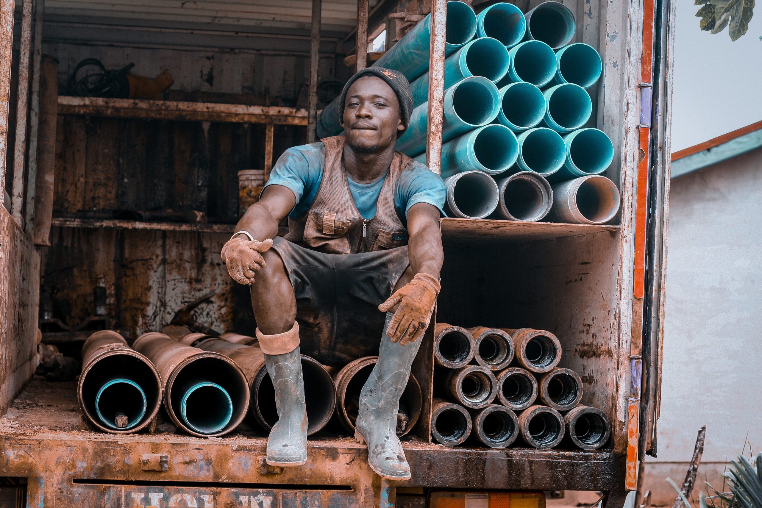 A worker sitting at a back of a car with drilling metals